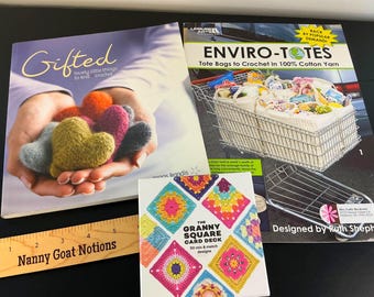 May include: Two craft books and a card deck. The left book is titled Gifted and shows hands holding felted hearts. The right book is titled Enviro-Totes and shows crochet bags in a shopping cart. A square Granny Square Card Deck sits in front.