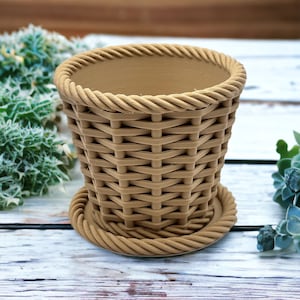 May include: A brown wicker-style plastic planter with a wide base and a narrow top. The planter has a rope-like design around the top and bottom.