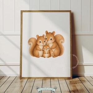 May include: A framed wall art print featuring a watercolour illustration of a family of three light brown squirrels. The two larger squirrels are positioned on either side of a smaller squirrel, all with bushy tails and smiling expressions.