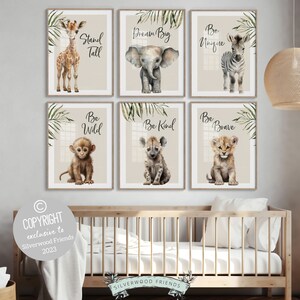May include: A collection of six framed art prints for a nursery, showcasing watercolour illustrations of safari animals such as a giraffe, elephant, zebra, monkey, hyena, and lion. Each print displays an inspirational message: "Stand Tall," "Dream Big," "Be Unique," "Be Wild," "Be Kind," and "Be Brave."
