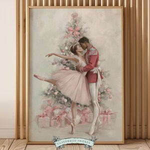 Puede incluir: Una impresión enmarcada representa una escena romántica de una bailarina y un príncipe besándose frente a un árbol de Navidad. La bailarina lleva un tutú rosa y el príncipe una chaqueta roja. El fondo presenta un árbol de Navidad con lazos rosas y regalos envueltos.