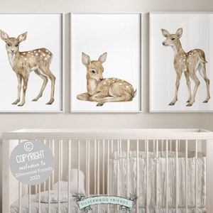 K&ouml;nnte beinhalten: Drei Aquarell-Illustrationen von Rehen auf wei&szlig;em Hintergrund. Die Rehe sind braun mit wei&szlig;en Flecken. Die Rehe sind in verschiedenen Posen, eines steht, eines liegt und eines schaut zur Seite. Die Illustrationen sind in wei&szlig;en Rahmen gerahmt.