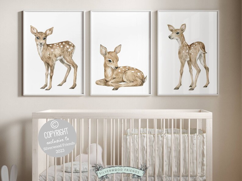 K&ouml;nnte beinhalten: Drei Aquarell-Illustrationen von Rehen auf wei&szlig;em Hintergrund. Die Rehe sind braun mit wei&szlig;en Flecken. Die Rehe sind in verschiedenen Posen, eines steht, eines liegt und eines schaut zur Seite. Die Illustrationen sind in wei&szlig;en Rahmen gerahmt.