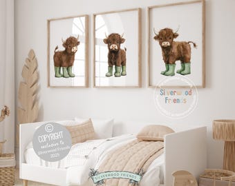 May include: Three printable art prints featuring watercolor illustrations of brown Highland cows wearing green rain boots. The prints are framed and displayed on a white wall above a beige bed.