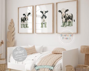 May include: Three framed watercolor prints of black and white cows wearing green rain boots. The artwork is displayed above a white bed with beige bedding. The copyright notice says "COPYRIGHT exclusive to Silverwood Friends 2025."
