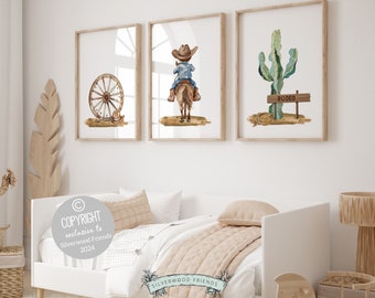 May include: Three watercolor illustrations in wooden frames, featuring a cowboy riding a horse, a wagon wheel, and a cactus with a sign that says "Rodeo".