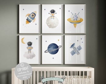 Può includere: Set di sei stampe ad acquerello con illustrazioni a tema spaziale. Le stampe raffigurano un astronauta, un razzo, un'astronave, un pianeta e un satellite. Le illustrazioni sono in tonalità di blu, giallo e grigio su uno sfondo bianco.