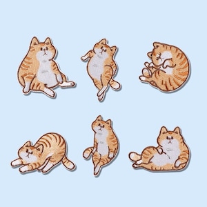 Może przedstawiać: Sześć haftowanych naszywek do prasowania z pomarańczowymi kotami tygrysimi w różnych pozach. Koty są wszystkie w stylu kreskówkowym i mają białe brzuchy.