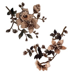 Pode incluir: Dois apliques florais bordados em tons de marrom e verde. Os apliques apresentam flores e folhas delicadas, perfeitas para adicionar um toque de elegância a roupas ou artesanato.