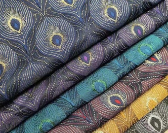 May include: A stack of fabric with a peacock feather pattern in various colors, including black, blue, green, and gold. The fabric is woven with a textured, iridescent finish.