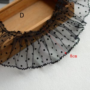 May include: Black polka dot mesh trim with a ruffled edge. The trim is 8 inches long.
