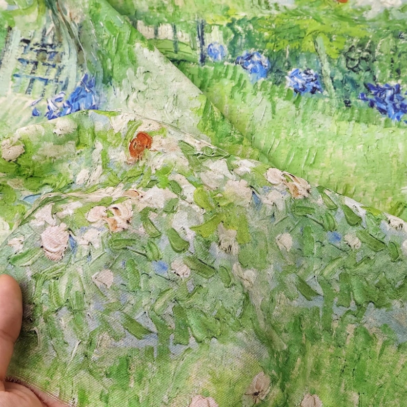 K&ouml;nnte beinhalten: Stoff mit einem gr&uuml;nen, wei&szlig;en und blauen impressionistischen Landschaftsdesign. Der Stoff hat ein strukturiertes, gemaltes Aussehen mit sichtbaren Pinselstrichen, das ein Feld aus Blumen und Bl&auml;ttern darstellt. Das Design erinnert an Natur und Kunst.