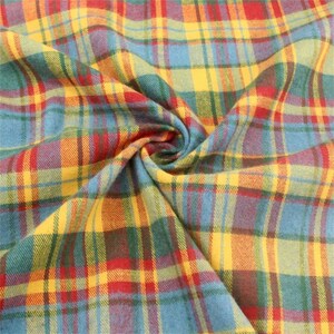 K&ouml;nnte beinhalten: Nahaufnahme eines lebendigen karierten Stoffes mit einer Mischung aus Farben. Das Muster besteht aus sich kreuzenden Linien in Rot, Gelb, Blau, Gr&uuml;n und Orange, die ein klassisches Karomuster bilden. Der Stoff ist dicht gewebt und wirkt weich.