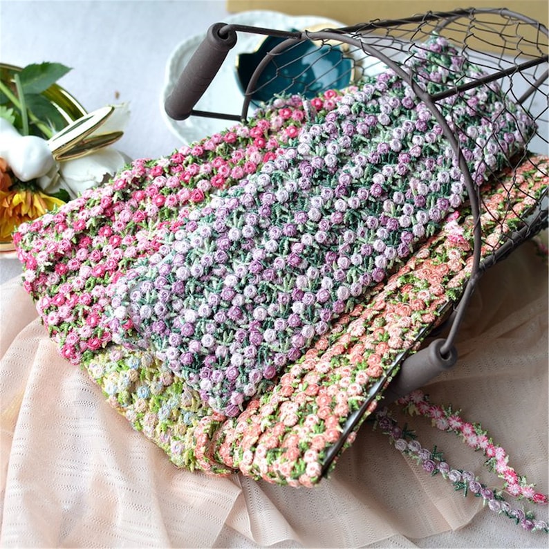 May include: Three rolls of floral trim with small pink, green, and peach flowers. The trim is made of a soft, delicate fabric and is perfect for adding a touch of elegance to any project.