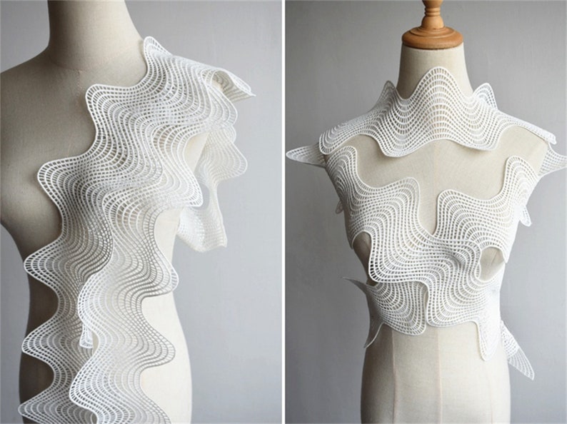 May include: White lace trim with a wavy, geometric pattern. The trim is shown on a dress form, both as a single piece and as a complete garment.