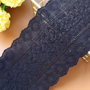 May include: Black cotton lace trim with a scalloped edge and a delicate floral pattern.