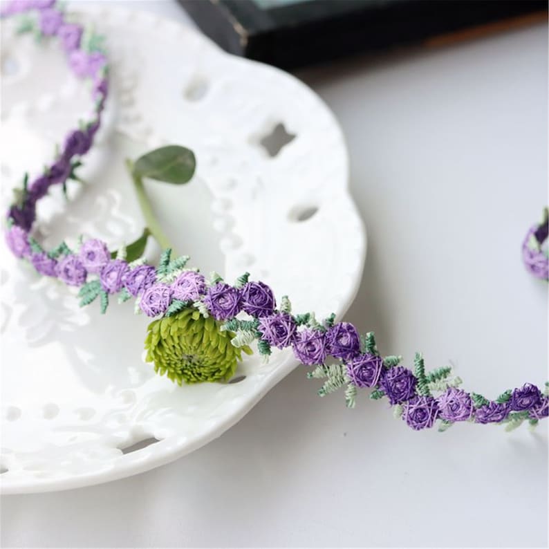 May include: Purple and green floral trim with small flower details.