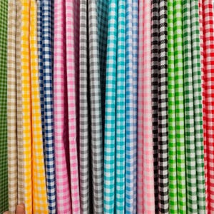May include: A collection of folded fabric strips featuring a classic gingham check pattern in various colours including yellow, blue, pink, grey, turquoise, black, lime green, and red, arranged vertically to display the repeating square design.