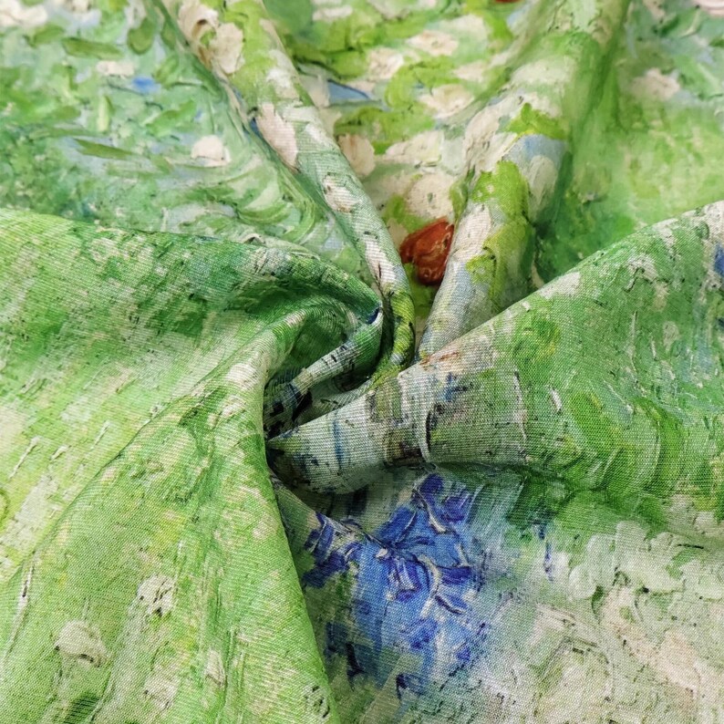 K&ouml;nnte beinhalten: Nahaufnahme eines Stoffes mit einem gr&uuml;nen, blauen und wei&szlig;en impressionistischen Gem&auml;ldedesign. Der Stoff hat ein strukturiertes Aussehen mit sichtbaren Pinselstrichen, und das Design zeigt eine Landschaft mit Blumen und B&auml;umen.