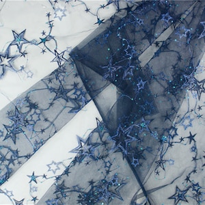 May include: Navy blue tulle fabric with embroidered silver glitter stars. The fabric is sheer and has a delicate, sparkly look.