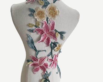 Könnte beinhalten: Eine florale Applikation mit rosa, weißen und gelben Blumen und grünen Blättern. Die Applikation ist aus besticktem Stoff gefertigt und eignet sich perfekt, um Kleidung oder Bastelarbeiten einen Hauch von Eleganz zu verleihen.