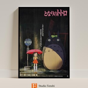 Puede incluir: Un p&oacute;ster vintage para la pel&iacute;cula de Studio Ghibli "Mi vecino Totoro" que muestra a una ni&ntilde;a con un paraguas rosa de pie junto a un gran Totoro gris bajo la lluvia. El p&oacute;ster tiene texto japon&eacute;s que dice "となりのトトロ" y "このへんないきものは、まだ日本にいるのです。たぶん。"  El p&oacute;ster tambi&eacute;n incluye el texto "原作・脚本・監督・宮崎駿" y "E Studio Tenshi".
