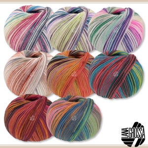 Op de afbeelding: Acht ronde bollen meerkleurig garen gerangschikt in een raster, elk met een uniek gestreept patroon. Het garen toont verschillende kleurcombinaties, waaronder roze, blauw, groen, oranje en neutrale tinten. Lana Grossa logo.