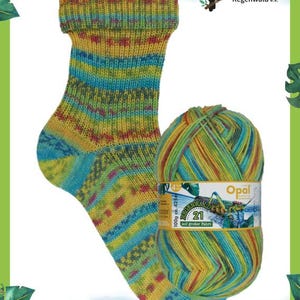 Könnte beinhalten: Eine bunte Stricksocke und ein Knäuel Wolle. Die Socke ist hauptsächlich gelb, blau und grün mit einem gemusterten Design. Das Garnknäuel hat ein passendes Farbschema. Das Bild enthält Text und ein Tukan-Logo.