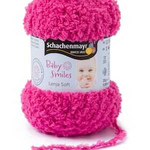 Può includere: Un gomitolo di lana rosa acceso Schachenmayr Baby Smiles Lenja Soft. La lana ha un aspetto morbido e strutturato, con un'etichetta che mostra il volto di un bambino. Il gomitolo di lana pesa circa 25g.