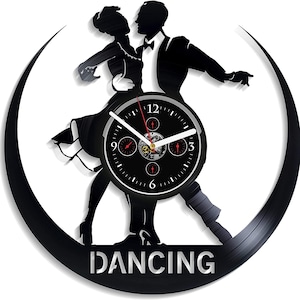 May include: Black vinyl record clock with a silhouette of a couple dancing. The clock face is black with white numbers and hands. The words "DANCING" are printed in silver below the couple.
