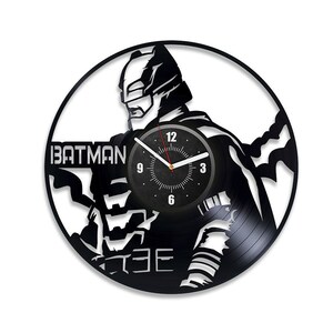 May include: Black vinyl record clock featuring a silhouette of Batman with the text "BATMAN" on the clock face. The clock face has a black background with white numbers and a red second hand.