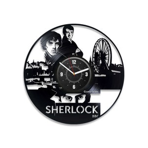 May include: Black vinyl record clock featuring a silhouette of the Sherlock Holmes characters, the London Eye, and the text "SHERLOCK BBC". The clock face has black Roman numerals and a red second hand.