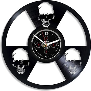 Könnte beinhalten: Schwarze Schallplattenuhr mit drei weißen Totenkopfdesigns und einem Zifferblatt mit römischen Ziffern.
