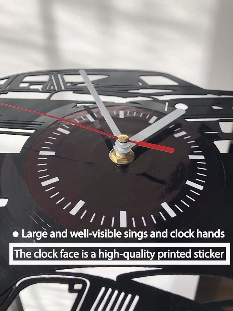 May include: Black vinyl record clock with a silhouette of a car. The clock face is a high-quality printed sticker with large, well-visible numbers and clock hands.
