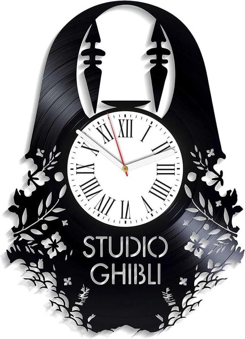 May include: Black vinyl record clock featuring a silhouette of No Face from the Studio Ghibli film Spirited Away. The clock face is white with black Roman numeral hour markers and black hands. The clock is surrounded by a floral design.