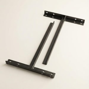 Puede incluir: Un marco de pata de mueble de metal negro con un diseño en forma de H, que cuenta con dos placas de montaje horizontales, cada una con cuatro orificios circulares pretaladrados para su fijación, unidos por una barra de soporte vertical central.