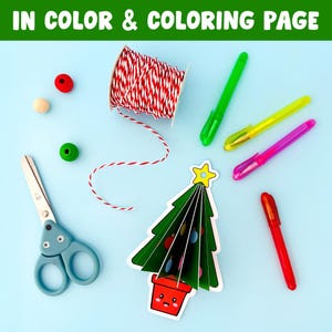 May include: A selection of craft materials on a light blue surface. Includes a green and white twine spool, pens, scissors, wooden beads, and a paper Christmas tree with the text "IN COLOR & COLORING PAGE".