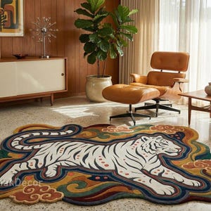 May include: A colorful rug featuring a white tiger with black stripes, set against a backdrop of orange, yellow, and blue cloud-like shapes. The rug is placed in a mid-century modern living room with a leather chair and wooden furniture.