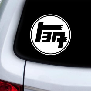 Puede incluir: Un círculo blanco con un logotipo de Toyota negro en su interior. El logotipo es una "T" estilizada con un "3" y un "7" a cada lado de la "T".