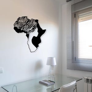 May include: Black metal wall art depicting the outline of the continent of Africa with a woman's face and hair styled in a traditional African headwrap.