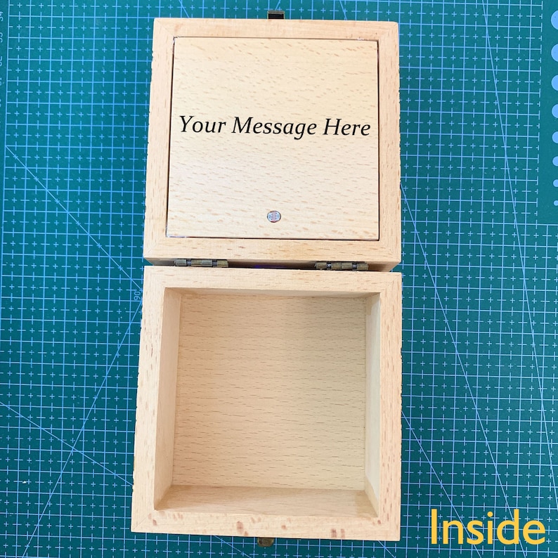 May include: A wooden box with a hinged lid. The lid is open and the inside of the box is empty. The lid has the text "Your Message Here" engraved on it.