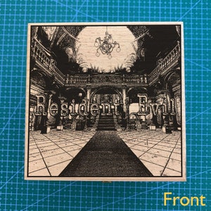 Könnte beinhalten: Eine Holzkiste mit einem Schwarzweißbild eines Herrenhaus-Innenraums. Der Text "Resident Evil" ist auf der Vorderseite der Kiste aufgedruckt.