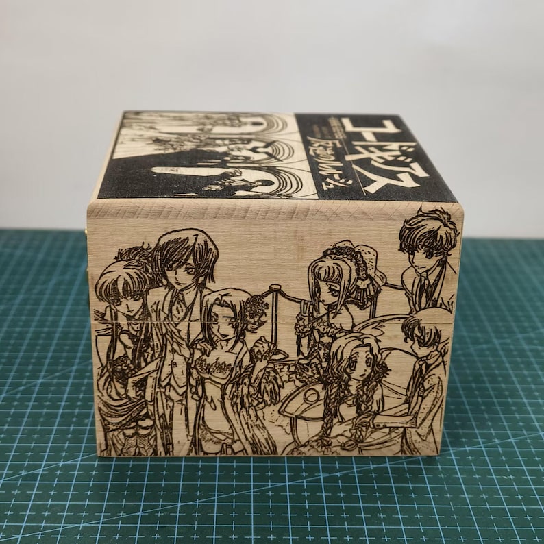 May include: A wooden box with a laser-engraved image of characters from the anime series Code Geass. The box is decorated with the Japanese text "Code Geass 反逆のルルーシュ" which translates to "Code Geass: Lelouch of the Rebellion".