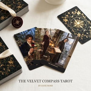 Może przedstawiać: Talia kart The Velvet Compass Tarot autorstwa Zane'a Mossa z ciemnozielonymi i złotymi niebiańskimi wzorami na odwrocie oraz zawieszką w kształcie kompasu. Trzy karty przedstawiają fotograficzne sceny osób w strojach historycznych.