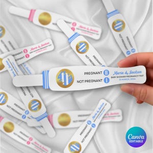 Op de afbeelding: Witte zwangerschapstests met blauwe en gouden details. De tests tonen de woorden "PREGNANT" en "NOT PREGNANT". Eén test is gelabeld "Maria & Jackson BABY SHOWER PREGNANCY TEST 31 MAART, 2026".