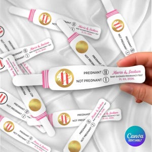 Puede incluir: Pruebas de embarazo blancas con detalles rosas y dorados. Las pruebas indican "Embarazada" y "No embarazada", junto con los nombres "Maria & Jackson" y la fecha "31, 03, 2026". Las pruebas están sobre un fondo blanco.