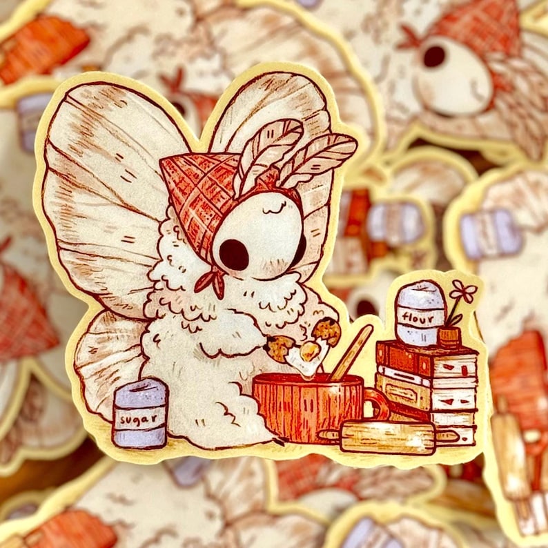 May include: A charming sticker depicting a cartoon moth character in a red and white checked bonnet, mixing ingredients in a wooden bowl. The sticker includes containers labelled "sugar" and "flour", and a rolling pin.