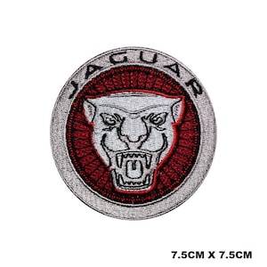 Puede incluir: Un parche bordado en plata y rojo con la palabra "JAGUAR" en un círculo alrededor de una cabeza de jaguar blanca con contorno negro. El parche mide 7,5 cm por 7,5 cm.