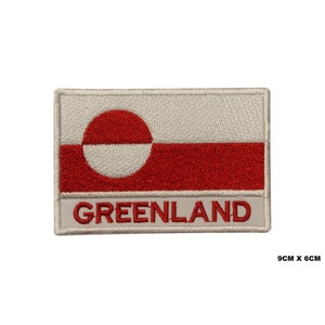 May include: An embroidered patch featuring the flag of Greenland. The flag is white with a red circle and a red horizontal stripe. The words "GREENLAND" are embroidered in white below the flag.