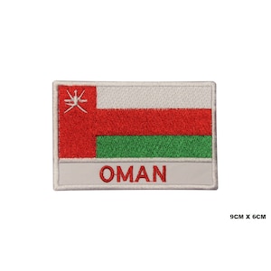 Pode incluir: Remendo retangular com a bandeira de Omã. O design da bandeira inclui um retângulo vermelho com um emblema branco, duas faixas vermelhas horizontais e uma faixa verde. A palavra "OMAN" é bordada em vermelho. Mede 9 cm por 6 cm.